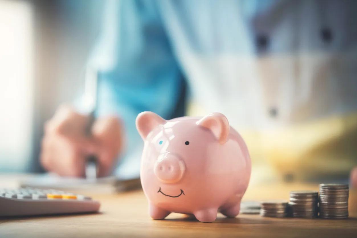 A saver putting money in a piggy bank